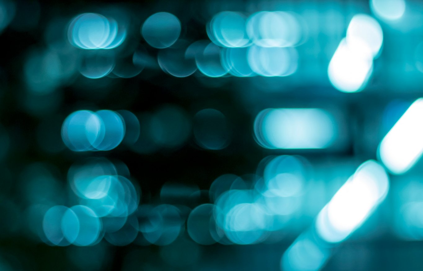 Out-of-focus teal points of light arranged in rows against a dark background